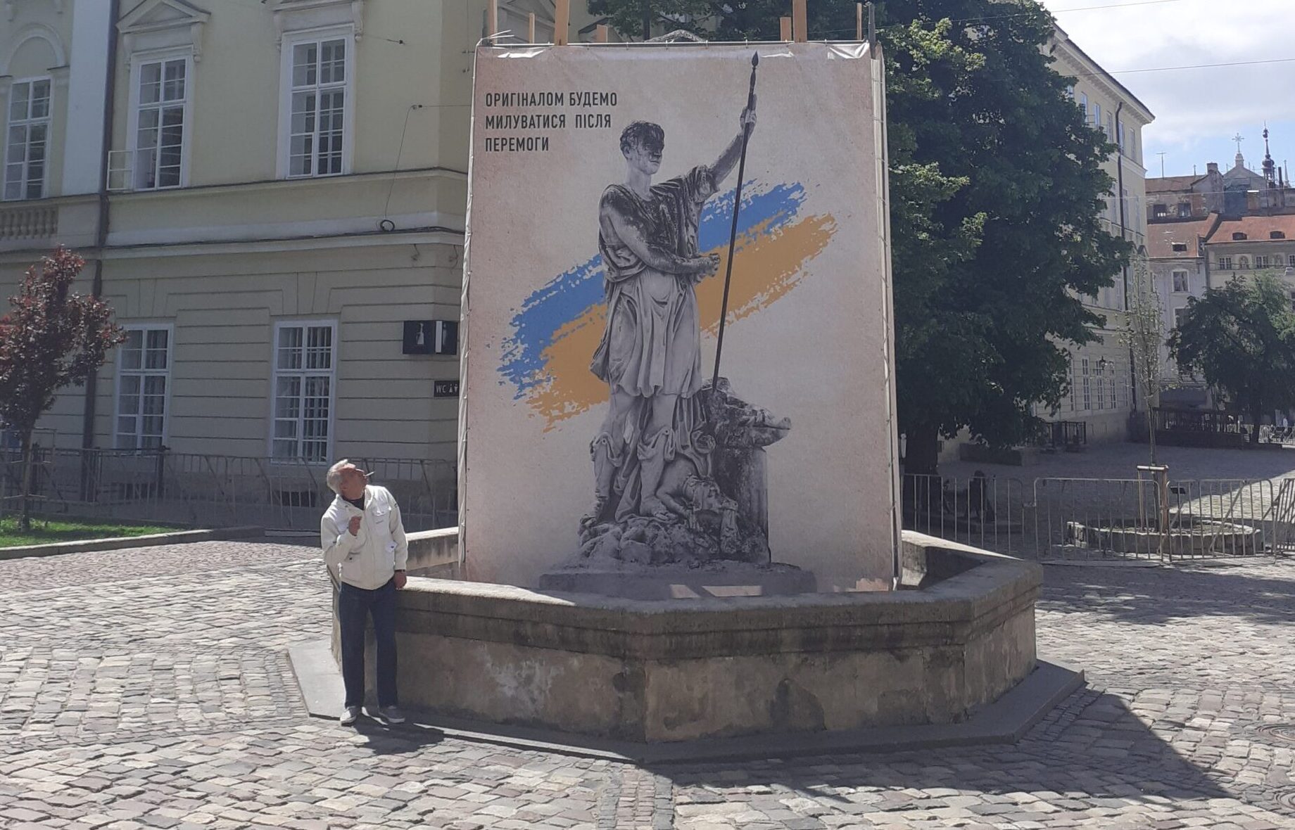 Rynok Square statues are removed and stored safely, the banner shows the statue, saying “The original will be returned after victory”, May 2022, Lviv. Foto Diana Vonnak